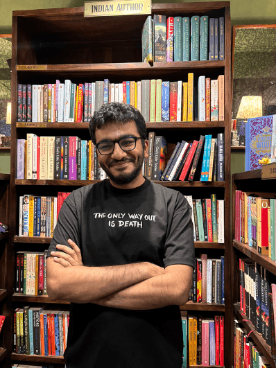 Varun Gwalani standing in front of bookshelves